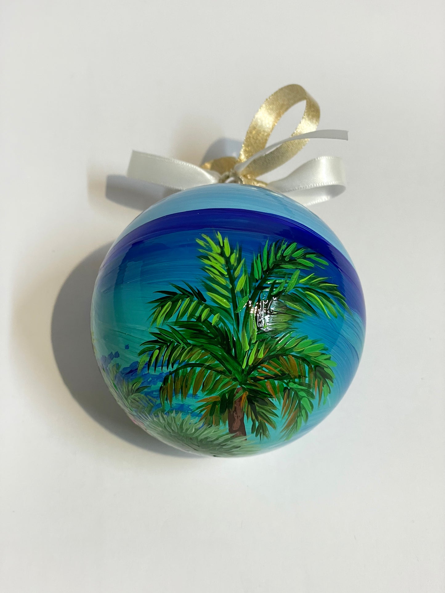 ornamento in vetro dipinto a mano, raffigura una spiaggia bianca delle Isole Canarie, palme e fiori e il mare cristallino.