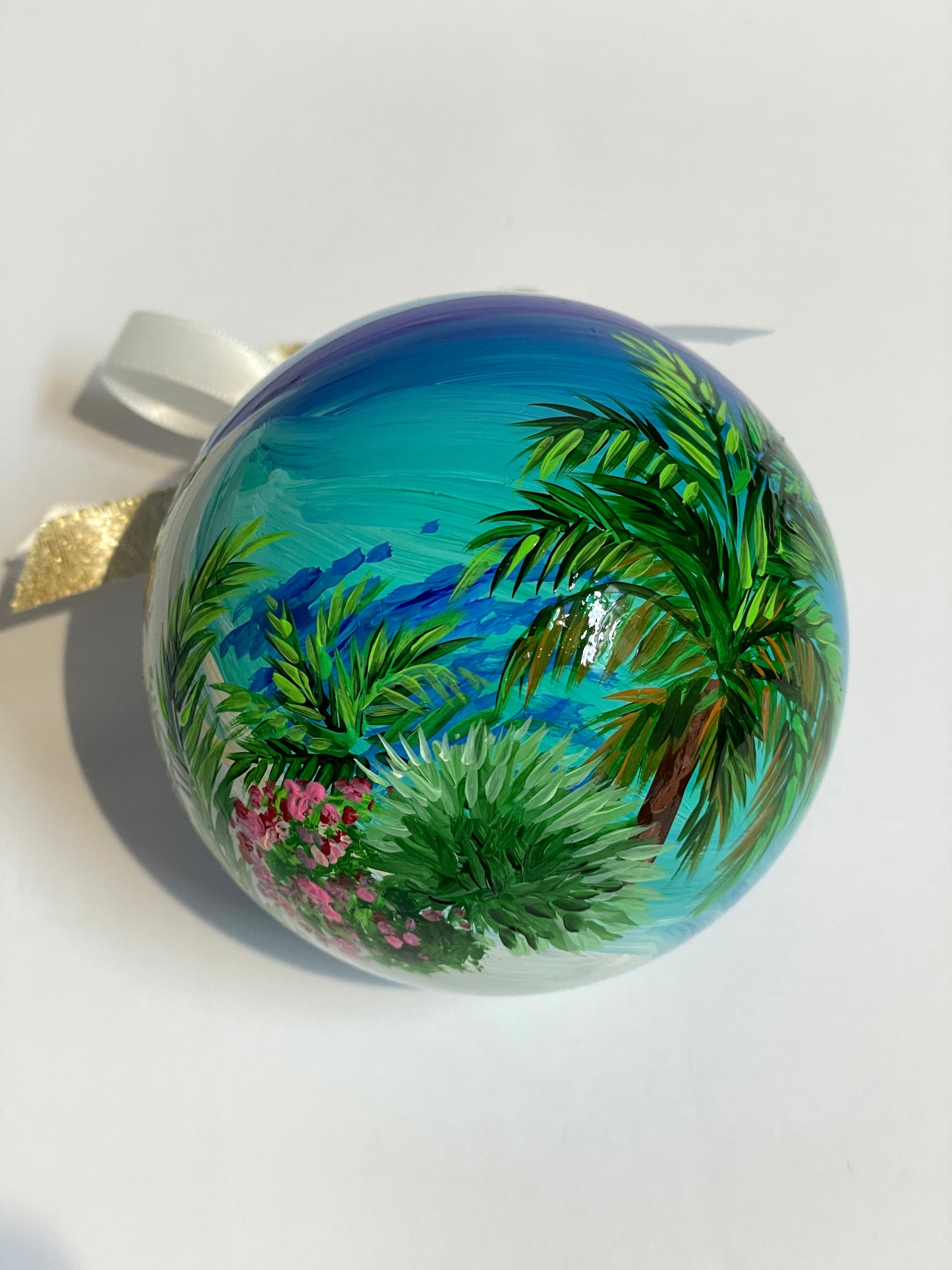 ornamento in vetro dipinto a mano, raffigura una spiaggia bianca delle Isole Canarie, palme e fiori e il mare cristallino.