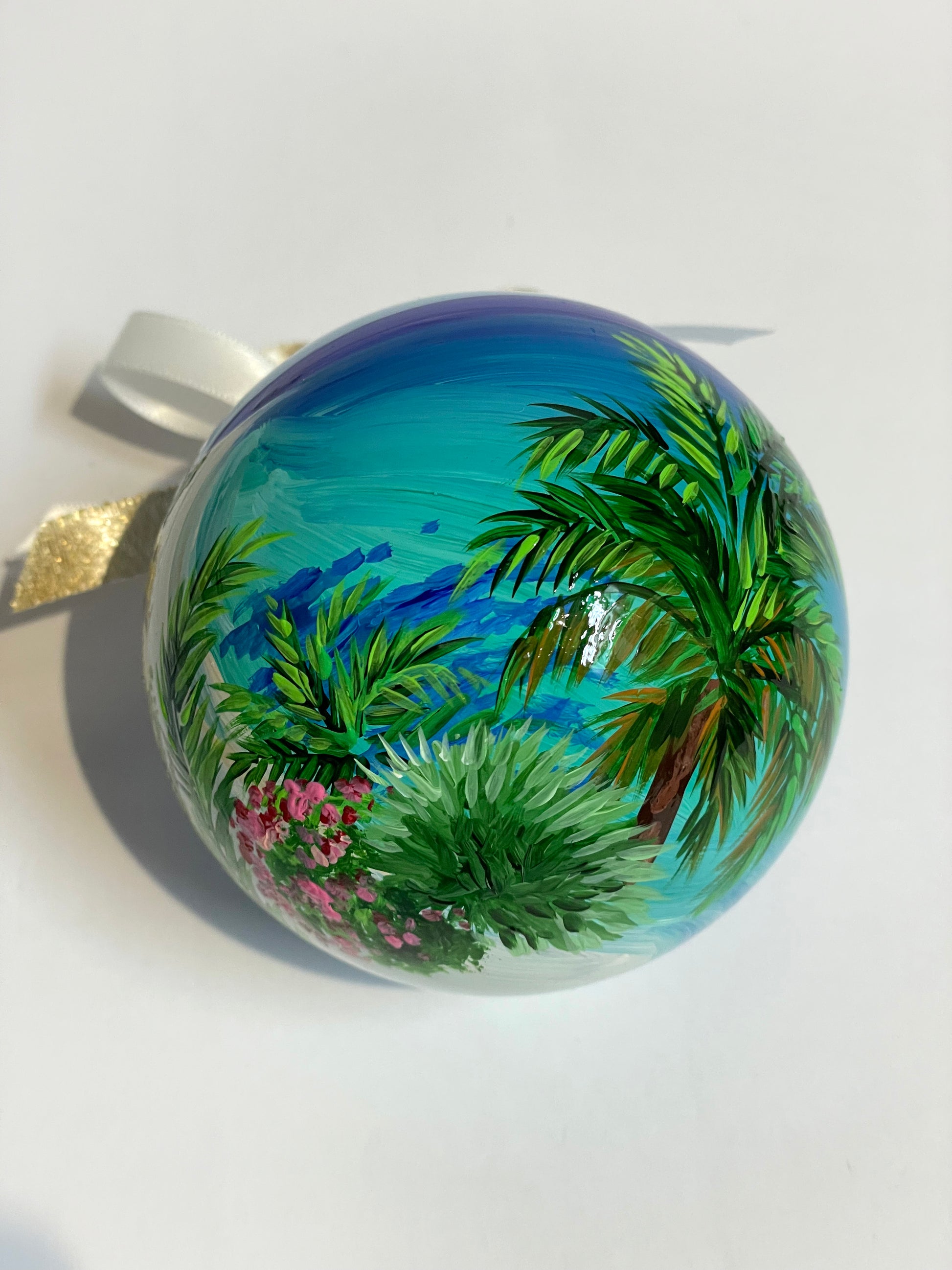 ornamento in vetro dipinto a mano, raffigura una spiaggia bianca delle Isole Canarie, palme e fiori e il mare cristallino.