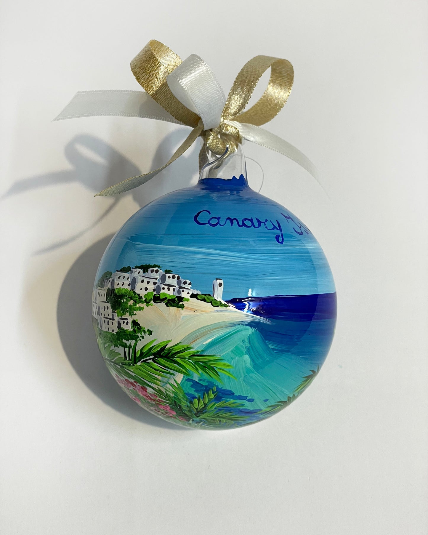 ornamento in vetro dipinto a mano, raffigura una spiaggia bianca delle Isole Canarie, palme e fiori e il mare cristallino.
