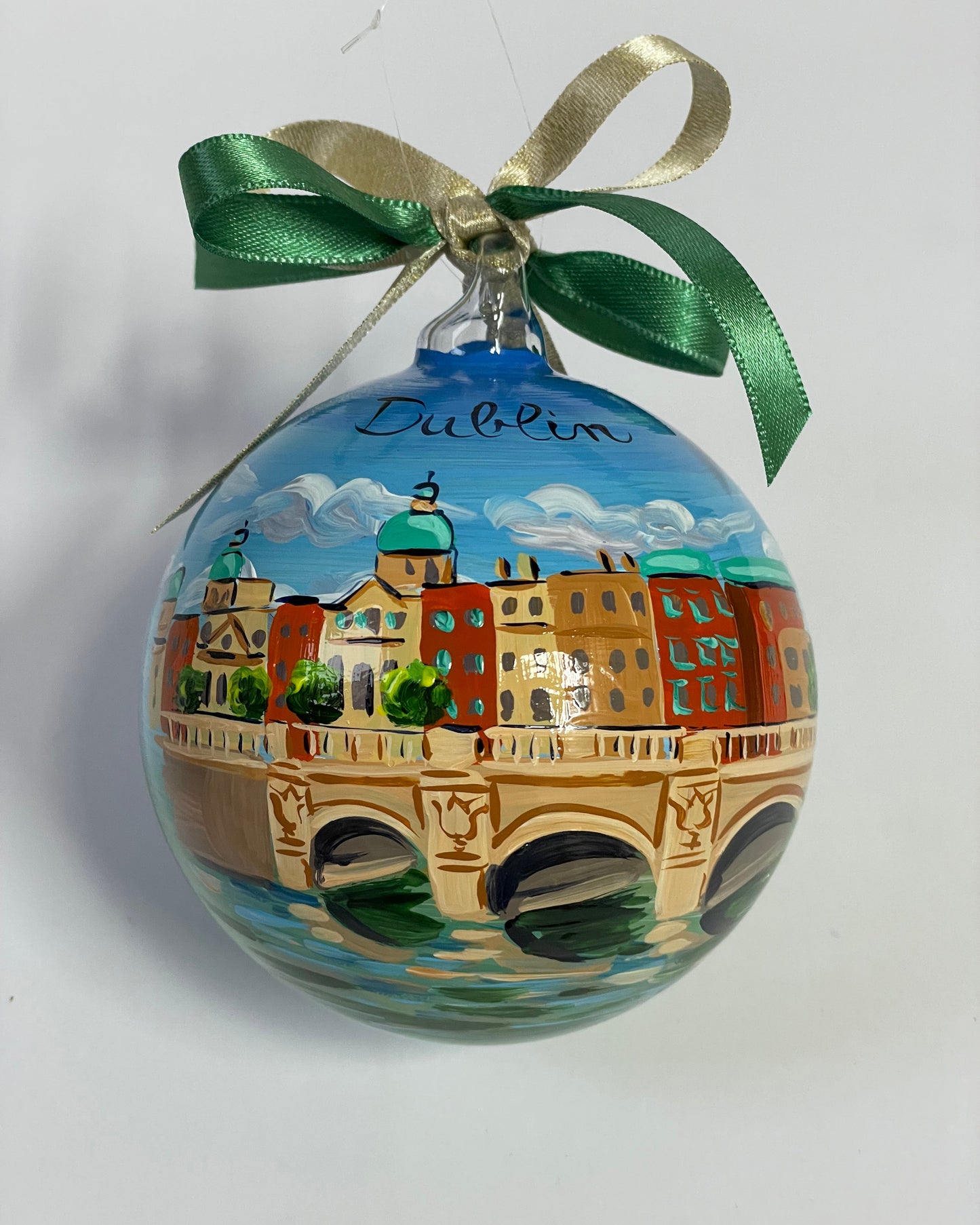 ornamento in vetro dipinto a mano con la città di Dublino, il cielo azzurro con nuvole bianche, un ponte sul fiume e gli edifici della città