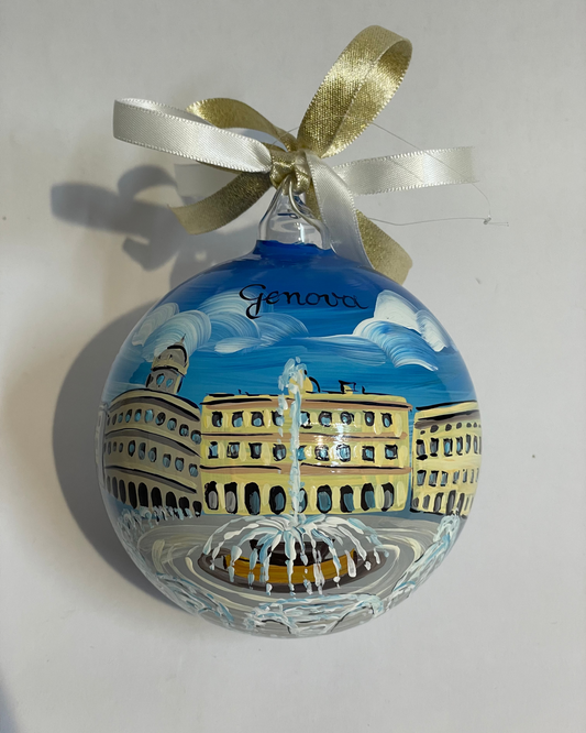 Ornamento di vetro dipinto a mano città di Genova, Italia. Piazza con grande fontana e case del centro città, cielo blu con nuvole.