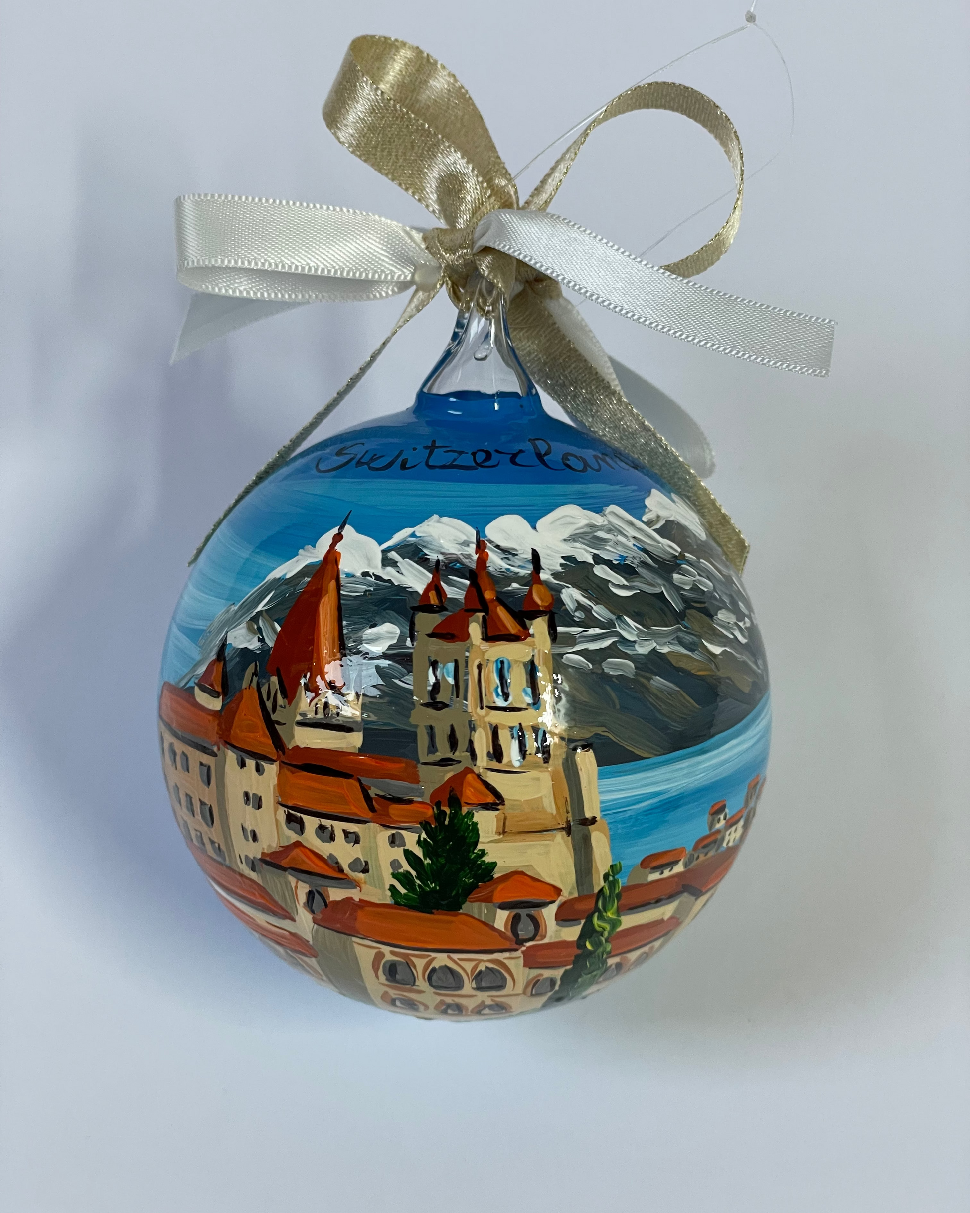 ornamento dipinto a mano con paesaggio della Svizzera con castello, lago e monti innevati