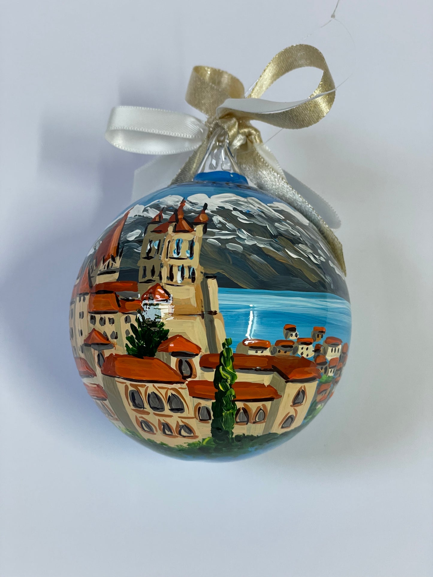 ornamento dipinto a mano con paesaggio della Svizzera con castello, lago e monti innevati