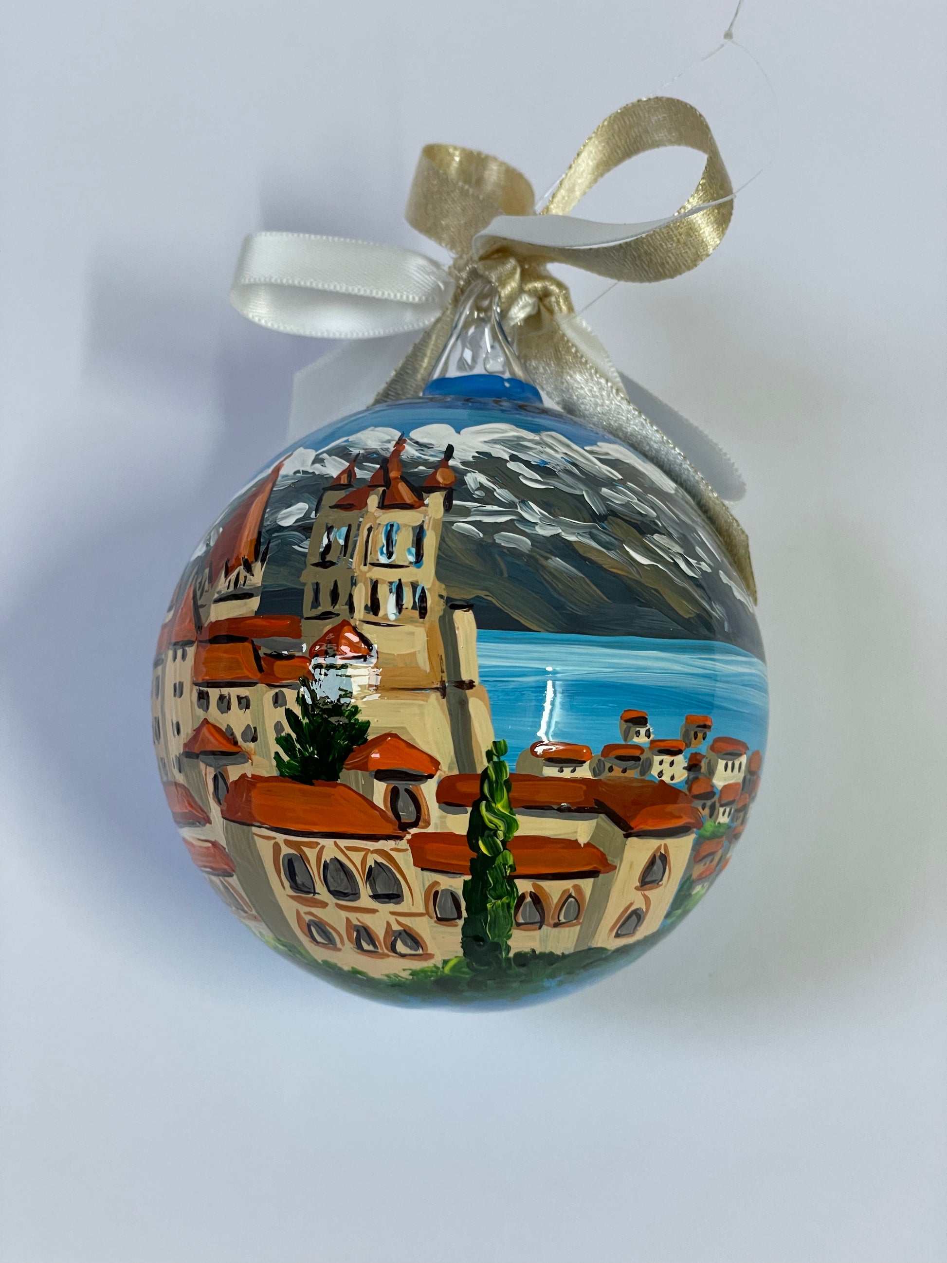 ornamento dipinto a mano con paesaggio della Svizzera con castello, lago e monti innevati