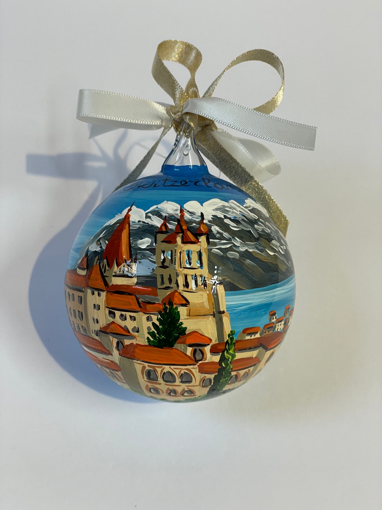 ornamento dipinto a mano con paesaggio della Svizzera con castello, lago e monti innevati