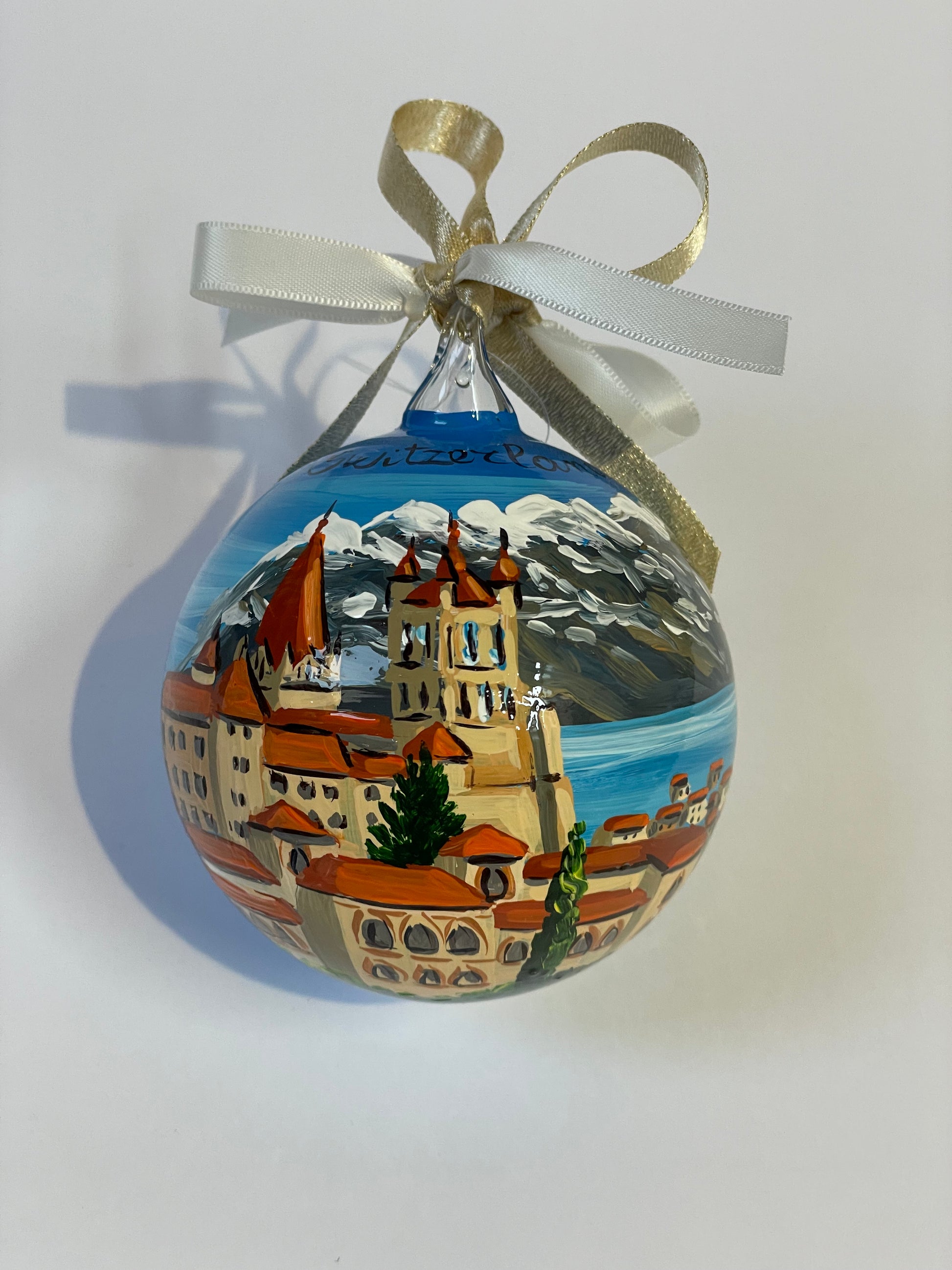 ornamento dipinto a mano con paesaggio della Svizzera con castello, lago e monti innevati