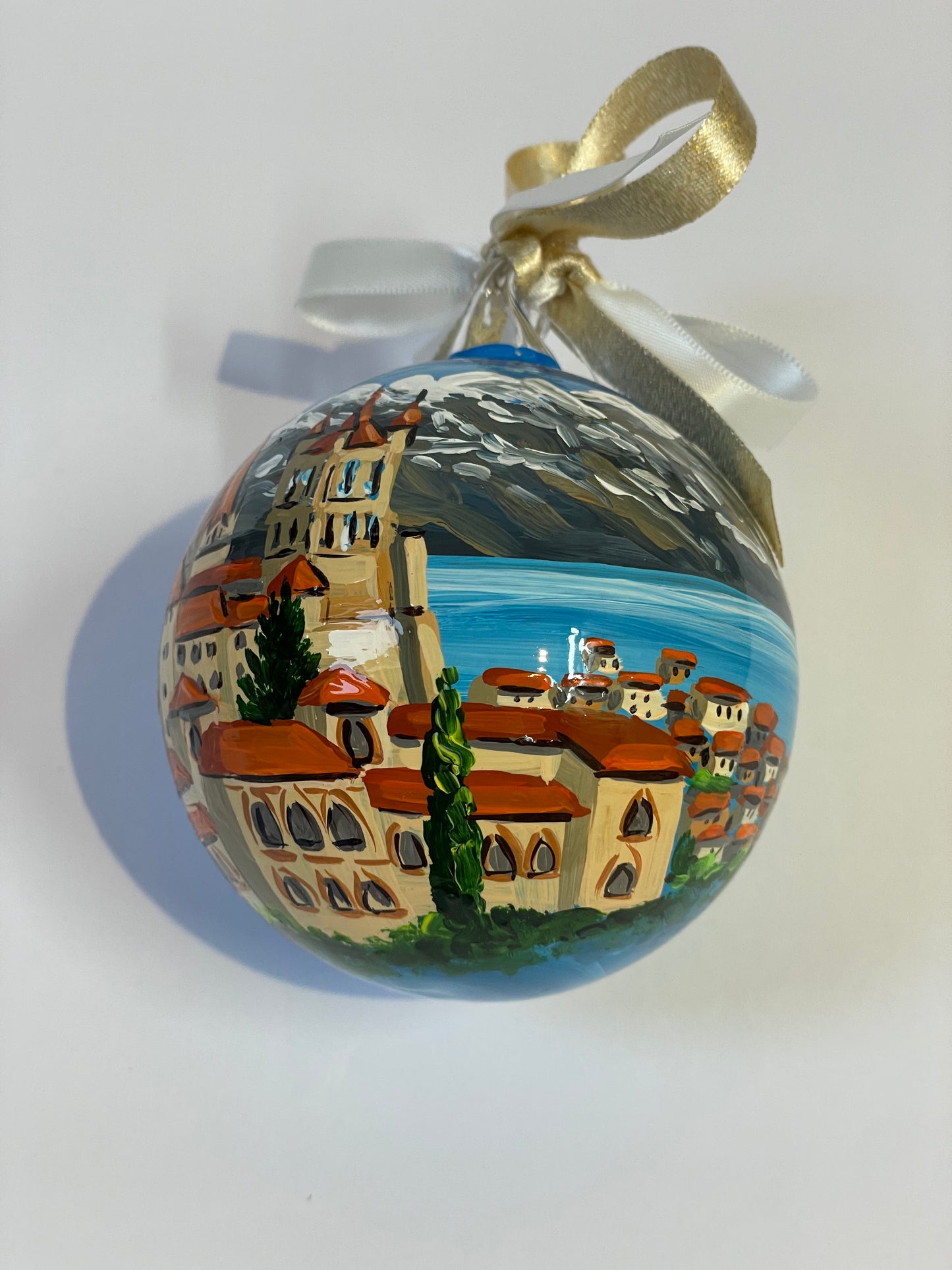 ornamento dipinto a mano con paesaggio della Svizzera con castello, lago e monti innevati