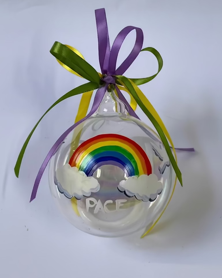 pallina di vetro decorata con l'arcobaleno della pace, due nuvole e colombe