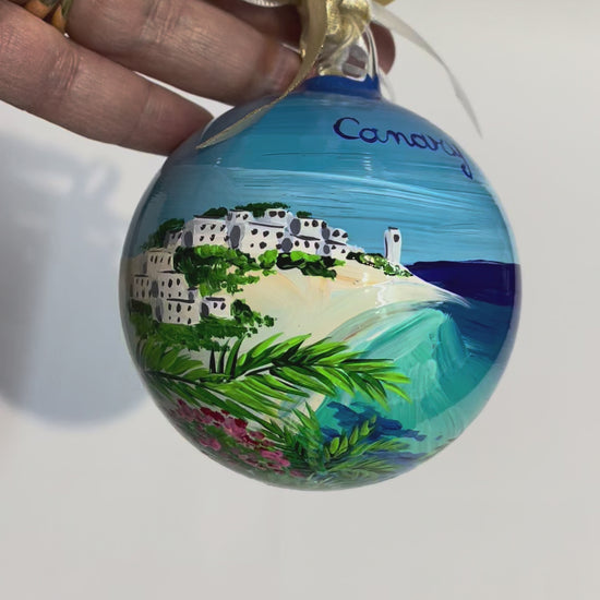 ornamento in vetro dipinto a mano, raffigura una spiaggia bianca delle Isole Canarie, palme e fiori e il mare cristallino.