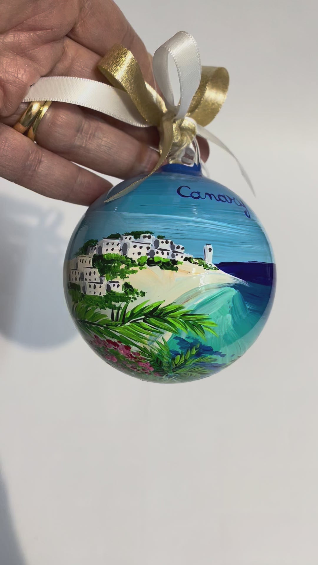 ornamento in vetro dipinto a mano, raffigura una spiaggia bianca delle Isole Canarie, palme e fiori e il mare cristallino.