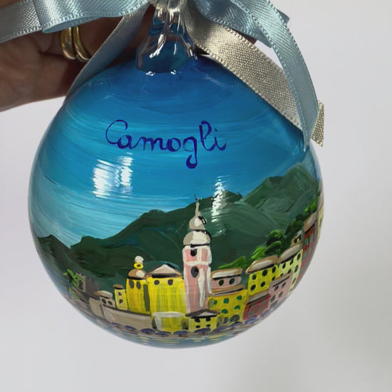 Ornamento in vetro dipinto a mano con Camogli, Liguria. E' raffigurato il borgo di case colorate affacciate sul mare, la spiaggia con gli ombrelloni 