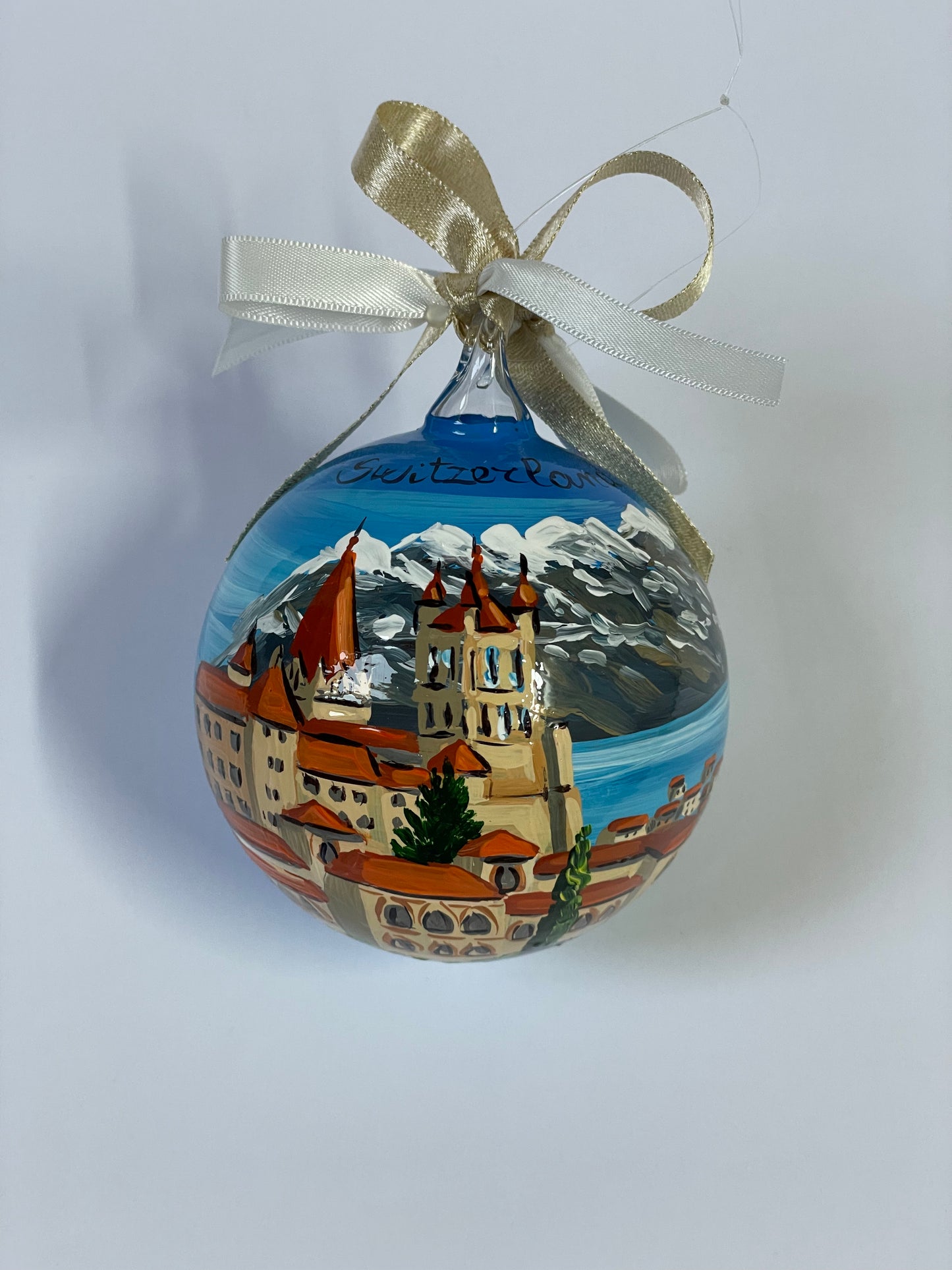 ornamento dipinto a mano con paesaggio della Svizzera con castello, lago e monti innevati